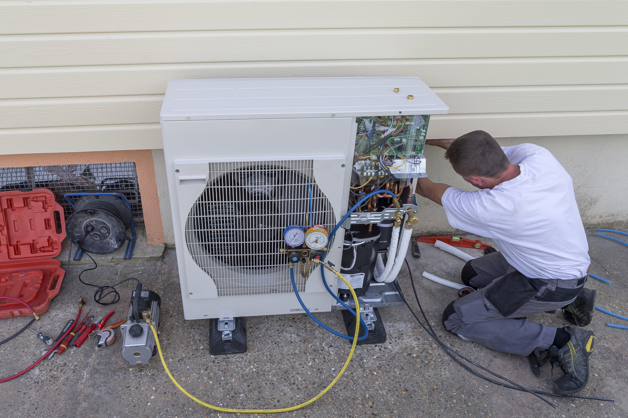 HVAC technician installing a heat pump outdoor unit
